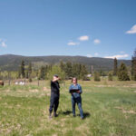Two people standing in a grassy field