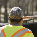 Rear view workers in yellow high-visibility vests