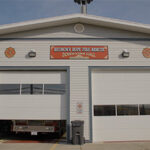 A fire station with a sign that reads "Hudson's Hope Fire Rescue Downtown Hall"